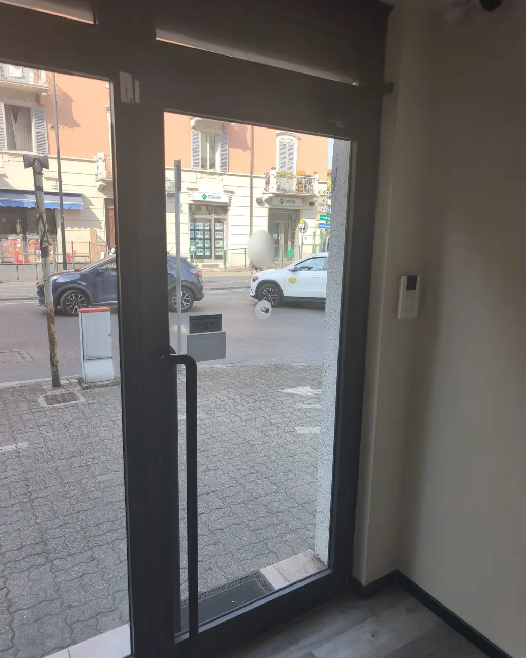 Ingresso vetrato di un negozio chiuso dalla saracinesca