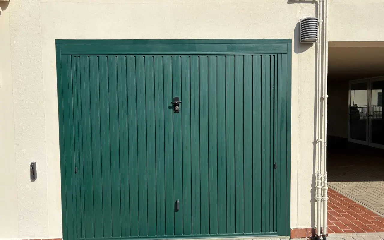 Porta basculante verde di un garage condominiale
