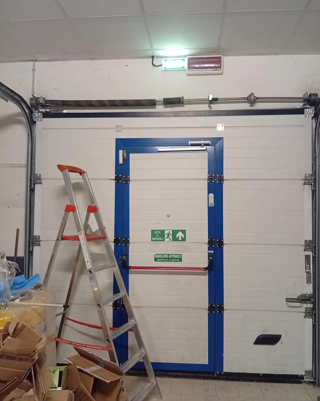 Portone sezionale di un capannone con porta pedonale